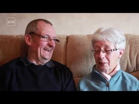 Husband and wife with dementia sitting together at home