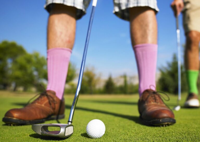 low angle photo of man playing golf taken at daytime