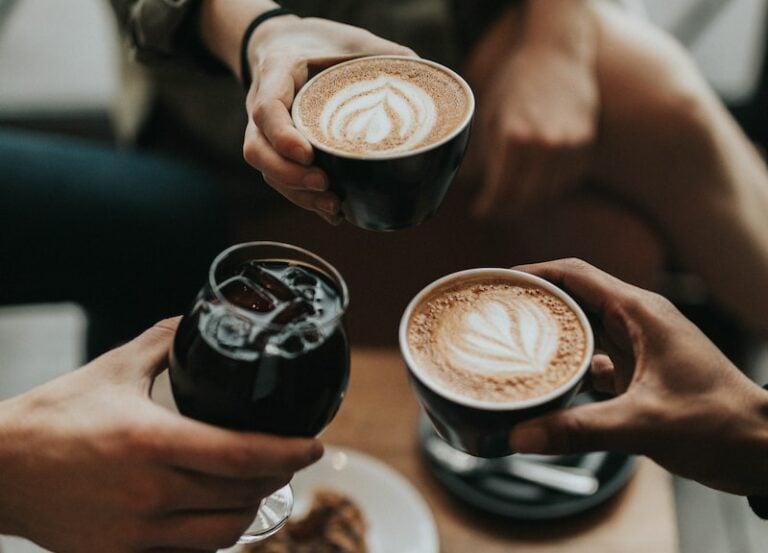 three person holding coffee mug and glass with soda inside