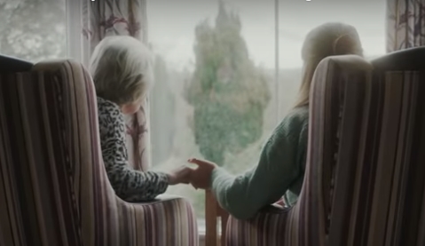 Grandmother and her daughter looking out a window