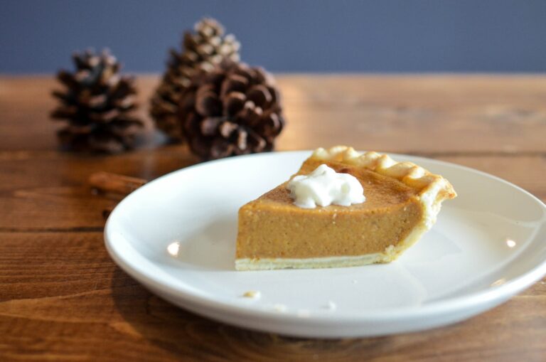 closeup photo of sliced pumpkin pie on white ceramic saucer