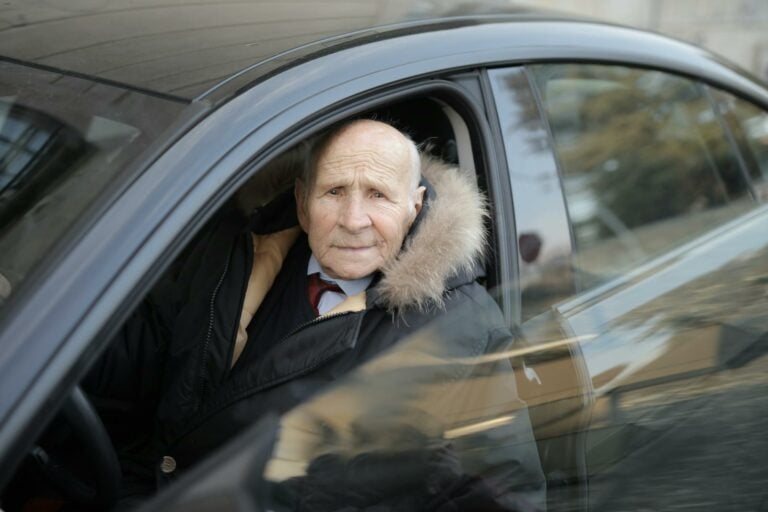 Elder Man in Black Jacket Sitting Inside Car