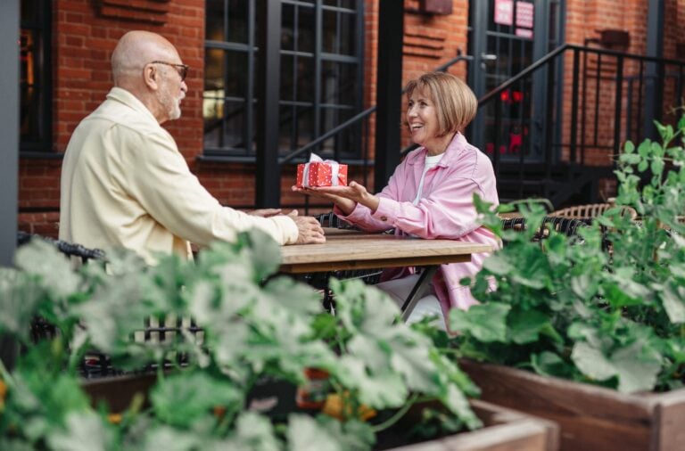 A Woman Giving a Gift to an Elderly Man