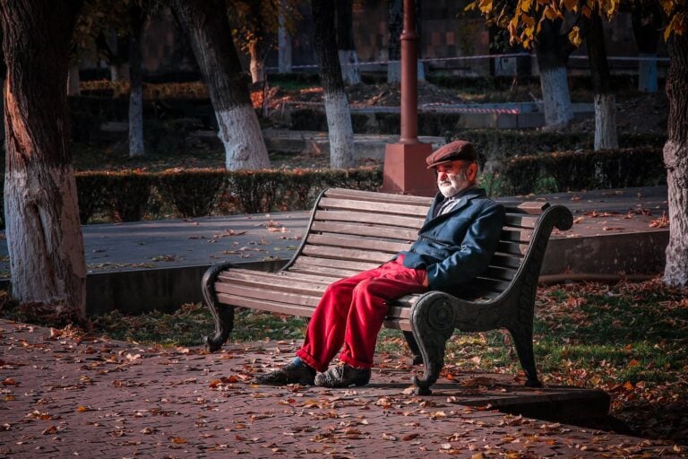 An Elderly Man Sitting on a Park Bench
