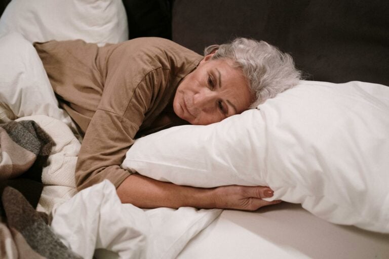 Elderly Woman Lying on White Pillow