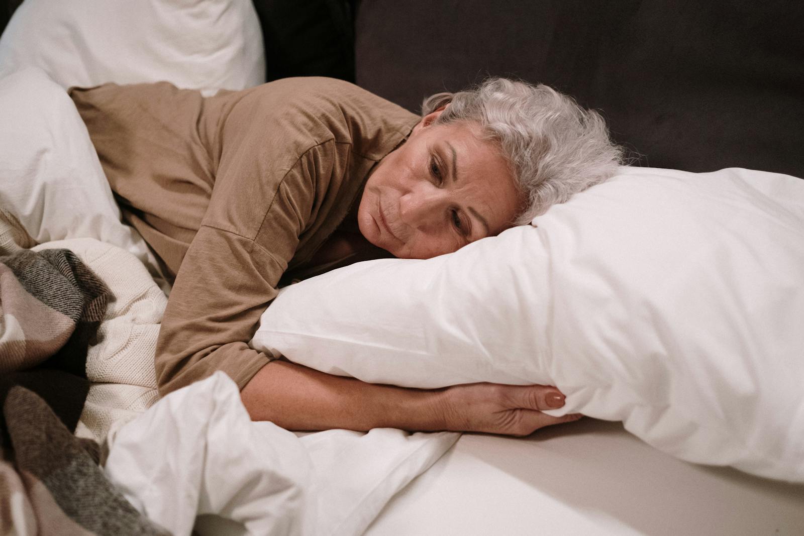 Elderly Woman Lying on White Pillow