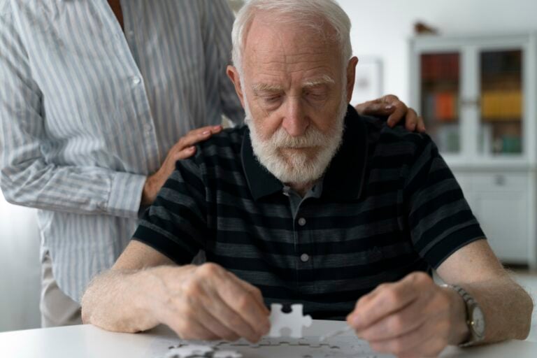 Elder man doing puzzle and confronting Alzheimer's