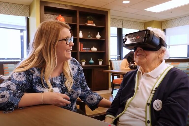 Care professional with dementia patient wearing virtual reality glasses