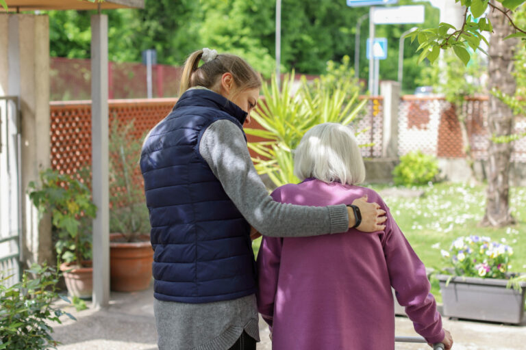 Young lady caring for elder woman with dementia